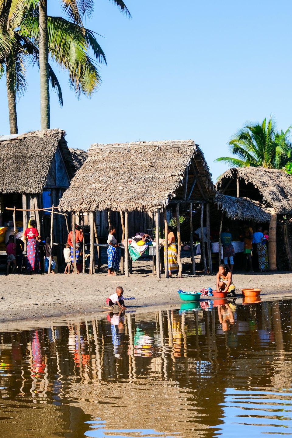 People go about their daily routines in a riverside village.